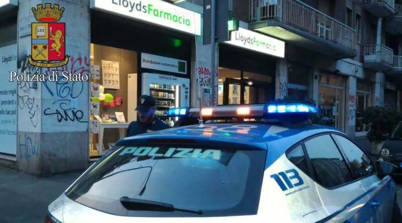 Foto di un'auto della polizia davanti ad una farmacia